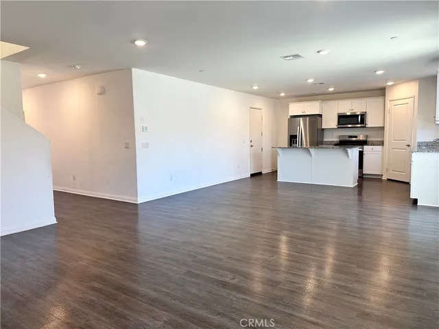 a view of kitchen with kitchen island stainless steel appliances refrigerator stove microwave and cabinets