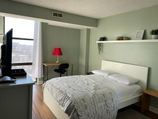 375 Ralph McGill Boulevard Northeast, Unit 1203 Atlanta, GA 30312 - Photo 12 of 12 a bedroom with a bed and a flat screen tv