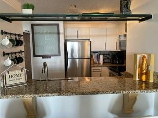 375 Ralph McGill Boulevard Northeast, Unit 1203 Atlanta, GA 30312 - Photo 3 of 12 a kitchen with kitchen island granite countertop a sink and a refrigerator