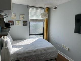 375 Ralph McGill Boulevard Northeast, Unit 1203 Atlanta, GA 30312 - Photo 5 of 12 a bedroom with a bed and a flat screen tv
