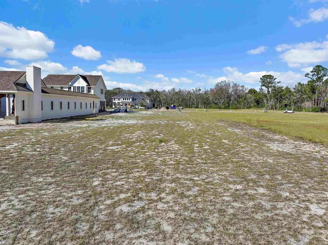 a view of a building with sitting area and garden