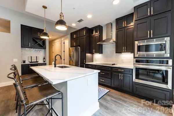 a kitchen with stainless steel appliances kitchen island a stove and a sink