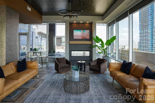 a living room with furniture flat screen tv and a large window