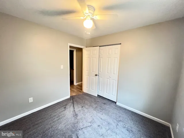 an empty room with a ceiling fan and a window