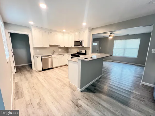 a kitchen with a sink cabinets and wooden floor