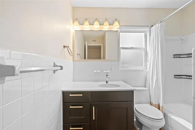 a bathroom with a sink vanity mirror and toilet