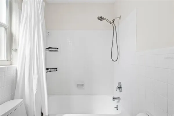 a bathroom with a bath tub with a shower