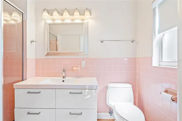 a bathroom with a sink mirror and toilet