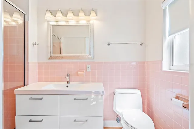 a bathroom with a sink mirror and toilet