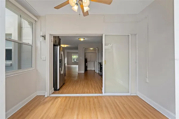 a view of a hallway with wooden floor and a chandelier