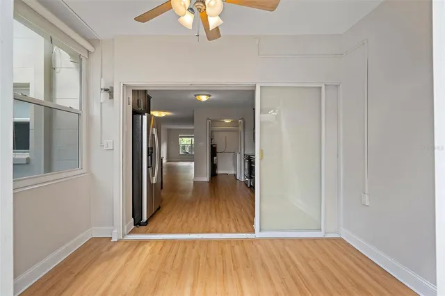 a view of a hallway with wooden floor and a chandelier
