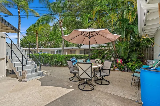a view of a patio with furniture and table under an umbrella