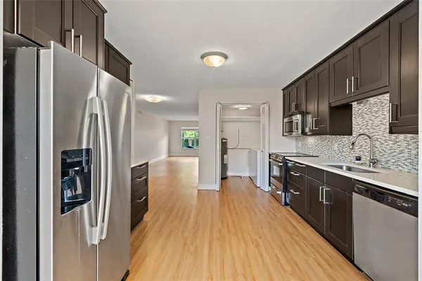 a kitchen with stainless steel appliances a refrigerator sink and microwave