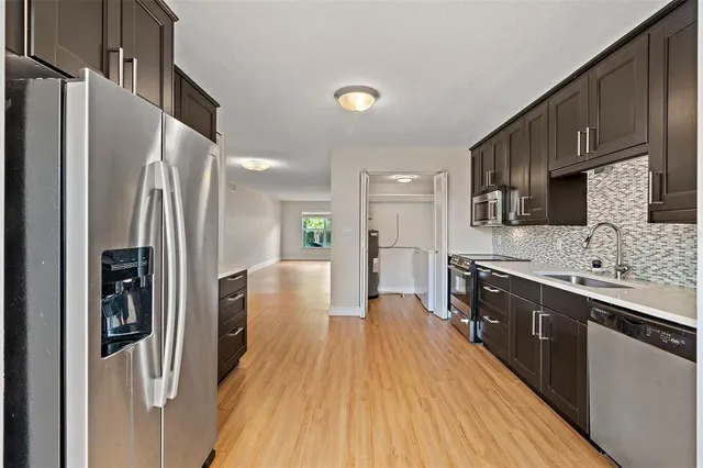 a kitchen with stainless steel appliances a refrigerator sink and microwave