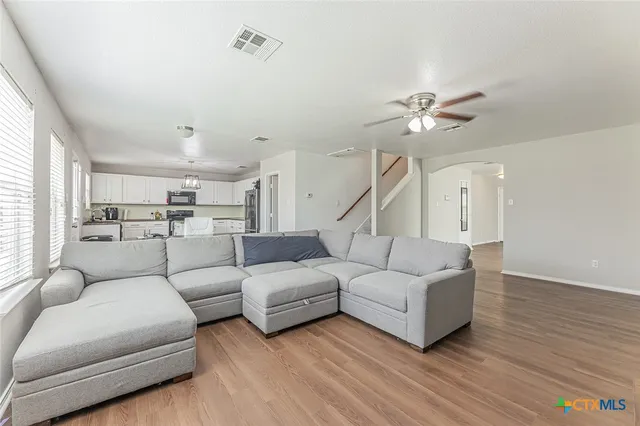 a living room with furniture and a wooden floor