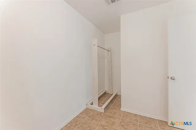 an empty room with windows and ceiling fan view