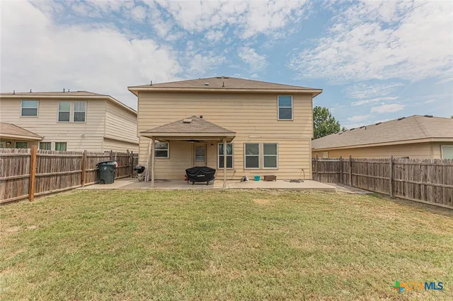 a view of a house with a patio and a yard