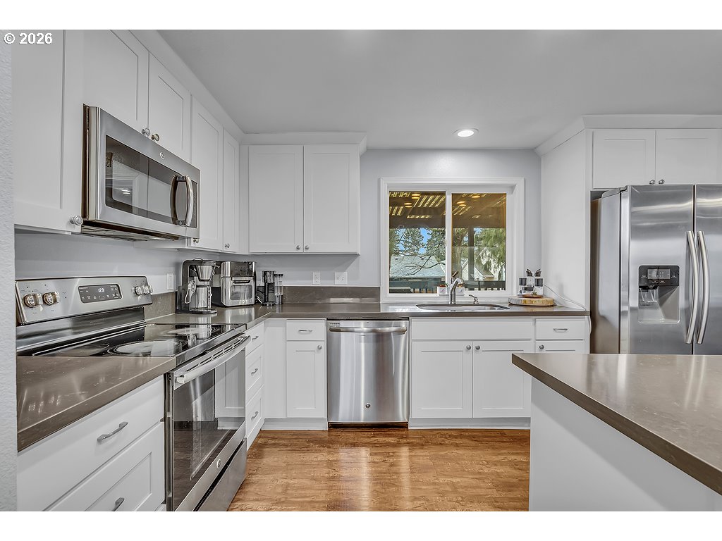 3893 Southwest 4th Street Gresham, OR 97030 - Photo 11 of 48 a kitchen with stainless steel appliances granite countertop a stove a sink and a microwave