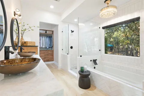 a spacious bathroom with a tub sink and mirror