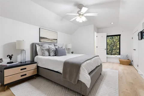 a spacious bedroom with a bed and a chandelier