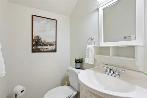 a bathroom with a toilet a sink and mirror