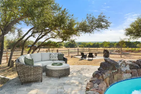 a view of a backyard with swimming pool and sitting area