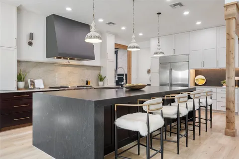 a kitchen with a table chairs sink and cabinets