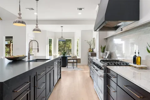 a kitchen with sink stove and cabinets