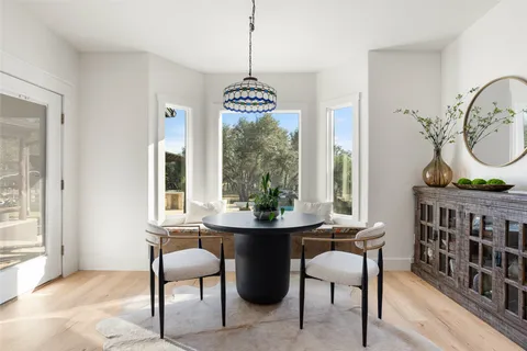 a dining room with furniture window and wooden floor
