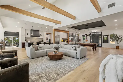 a living room with furniture and a view of kitchen