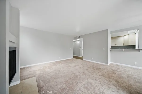 an empty room with a chandelier fan and wooden floor