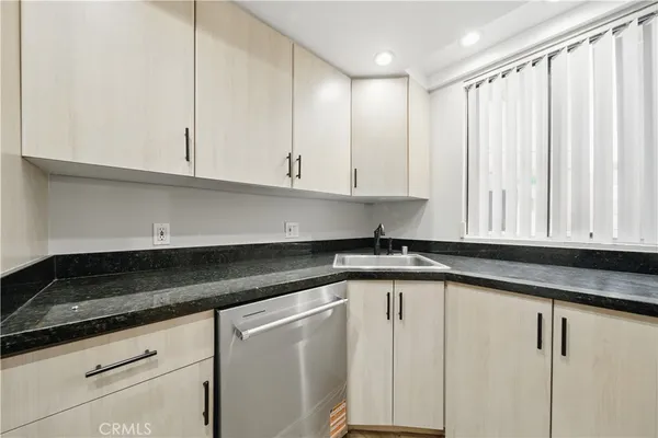 a kitchen with stainless steel appliances granite countertop a stove microwave and sink