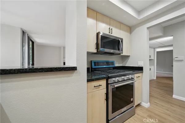 a kitchen with stainless steel appliances granite countertop a refrigerator and a stove top oven
