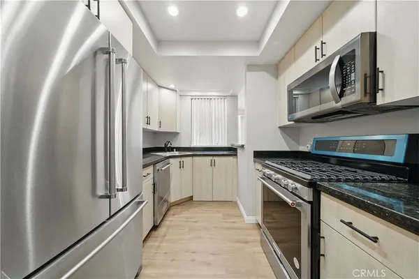 a kitchen with stainless steel appliances a refrigerator sink and stove