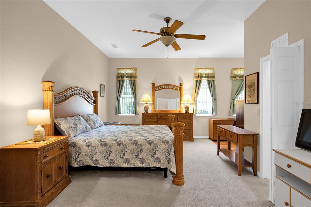 10777 Southwest 71st Circle Ocala, FL 34476 - Photo 22 of 47 a bedroom with a bed and a chandelier