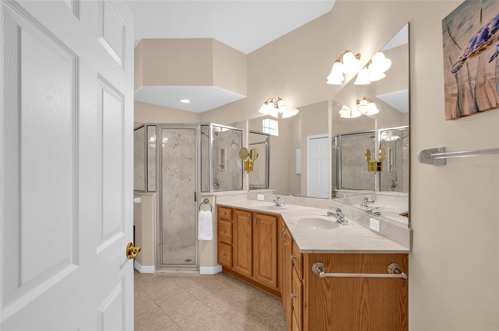 10777 Southwest 71st Circle Ocala, FL 34476 - Photo 28 of 47 a bathroom with a sink mirror and a shower