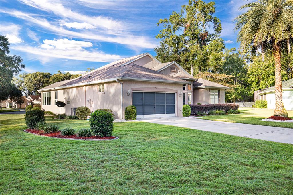 10777 Southwest 71st Circle Ocala, FL 34476 - Photo 3 of 47 a front view of a house with a garden and plants