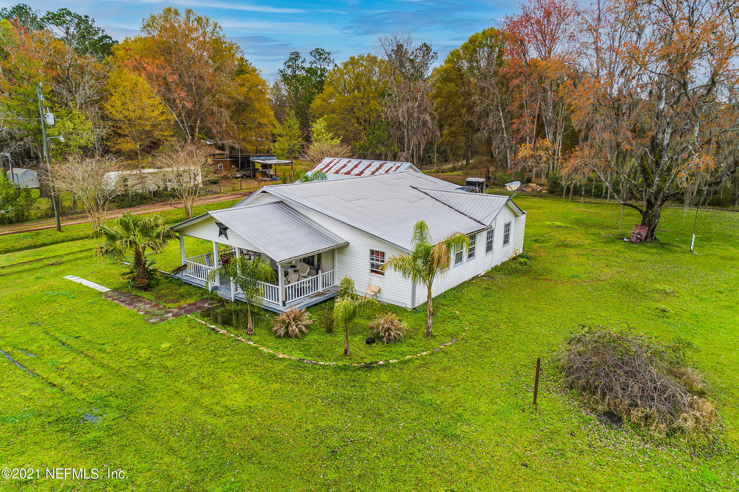 56117 Griffin Road Callahan, FL 32011 - Photo 2 of 30 an aerial view of a house with swimming pool and trees all around