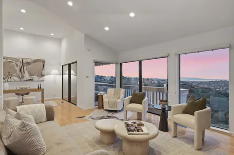 a living room with furniture and a floor to ceiling window