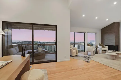 a living room with furniture a large window and a flat screen tv