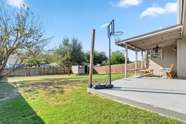 a view of a house with backyard and a tree