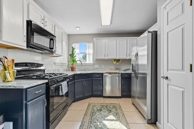 a kitchen with stainless steel appliances granite countertop a refrigerator stove top oven and sink