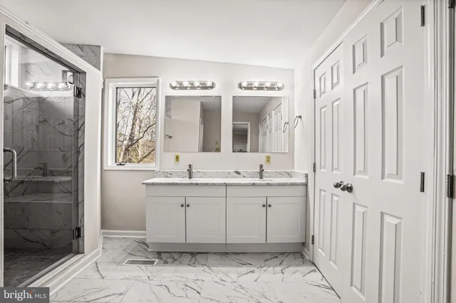 a spacious bathroom with a granite countertop sink a mirror and a shower
