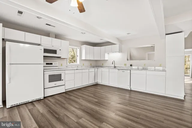 a kitchen with white cabinets and white appliances