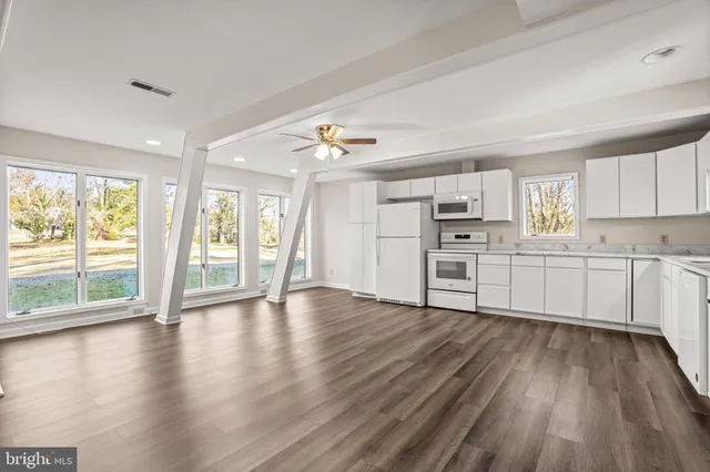 a view of a kitchen with wooden floor and electronic appliances