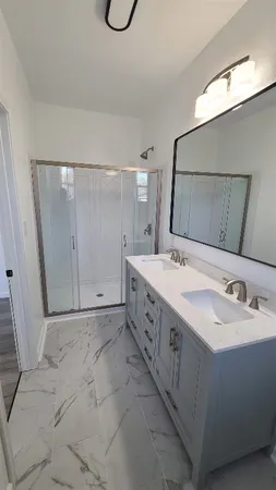 a spacious bathroom with a double vanity sink a mirror and a bathtub