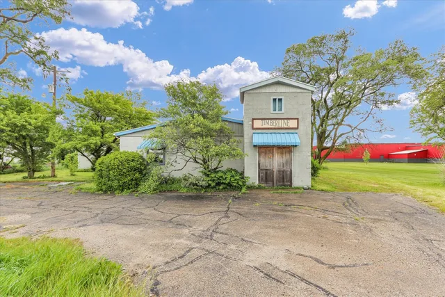 a front view of a house with a garden and trees