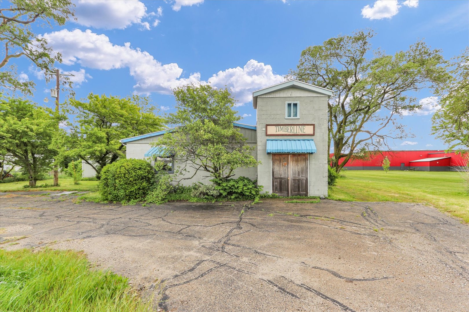 a front view of a house with a garden and trees