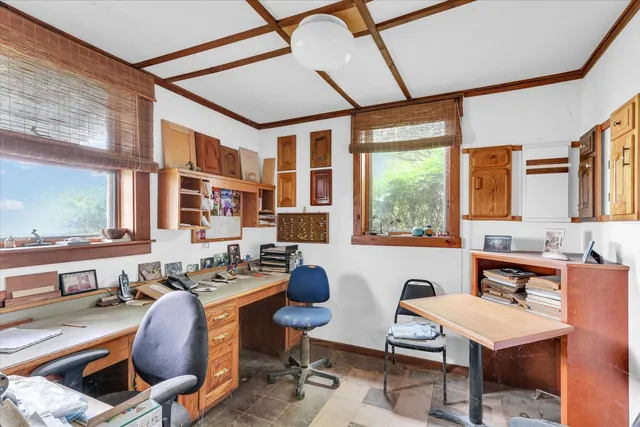 a work place with furniture and large windows