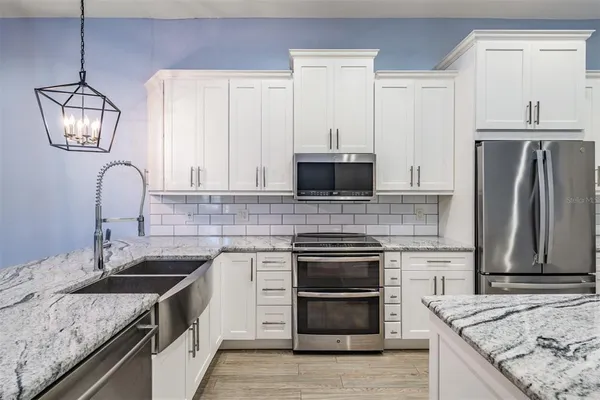 a kitchen with granite countertop a sink stainless steel appliances and cabinets